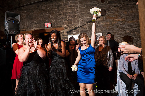 single lady holds bouquet in air after catching it