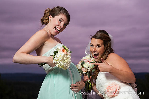 bridesmaid pointing at belly of pregnant bridesmaid