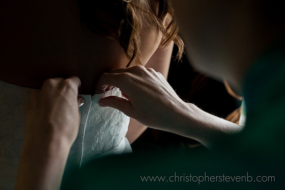 detail photo of wedding dress being fastened